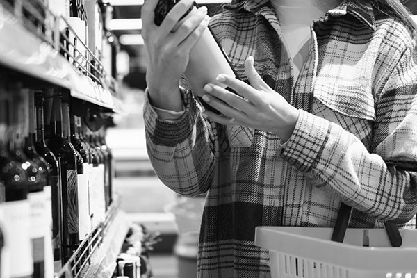 mulher fazendo compras na seção de vinhos totalmente abastecida